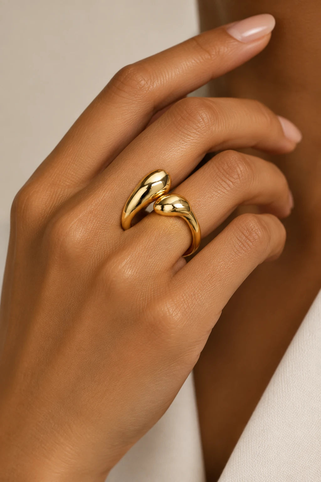 Mão com o anel Bloom Vintage dourado de duas gotas